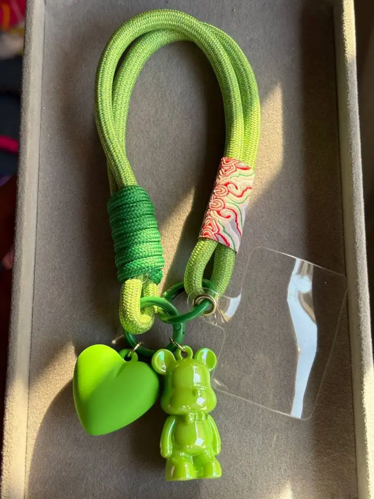 Green phone holder with 2 charms